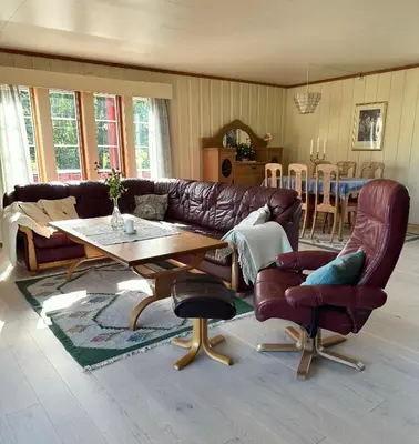 a living room with a leather couch and a table at Villa Soltun in Ringebu