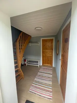 a hallway with wooden doors and a rug at Vågen Fjordbuer - Snekkerbua in Ravlo