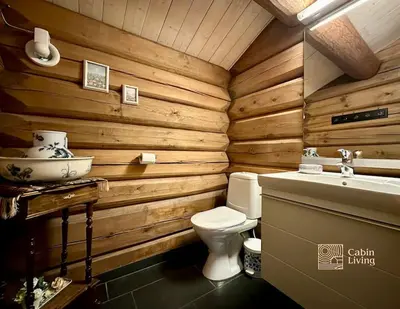 a wooden bathroom with a toilet and a sink at Large log cabin at Sjusjøen with sauna, fireplace and panoramic view in Ringsaker
