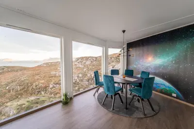 a dining room with a table and chairs and large windows at Runde Panorama - Highlight View in Runde