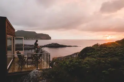 a man standing on a balcony looking at the ocean at Runde Panorama - Eden in Runde