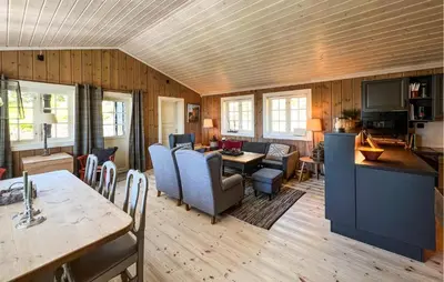 a living room with a table and a dining room at Amazing Home In Sjusjøen With Sauna in Sjusjøen