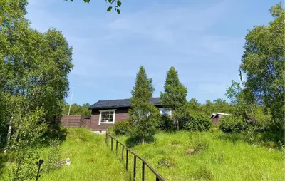 a house in a field with a fence at 2 Bedroom Pet Friendly Home In Haddal in Haddal