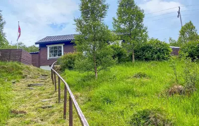 a house on a hill with a fence in the grass at 2 Bedroom Pet Friendly Home In Haddal in Haddal