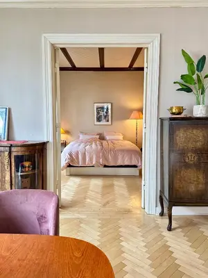 a bedroom with a bed and a table in a room at Authenic Art Nouveau Apartment in the city-center in Ålesund