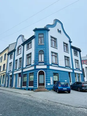 a blue building with a car parked in front of it at Authenic Art Nouveau Apartment in the city-center in Ålesund
