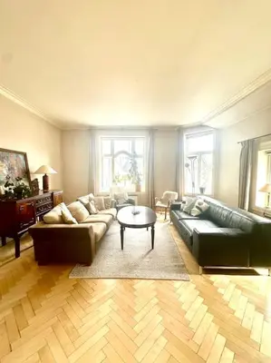 a living room with a couch and a table at Authenic Art Nouveau Apartment in the city-center in Ålesund