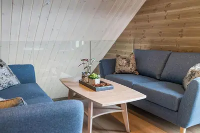 a living room with two blue couches and a table at Mountain View Apartment - penthouse in Stranda