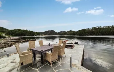 a table and chairs on a dock on a body of water at Stunning Home In Førde I Hordaland in Erve