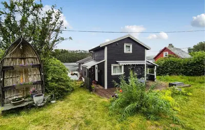 a black house and a barn in a yard at Stunning Home In Førde I Hordaland in Erve
