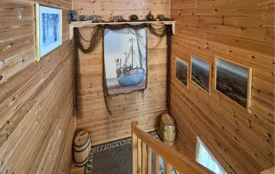a staircase in a wooden cabin with a boat on the wall at Lovely Home In Urangsvåg in Steinsbø