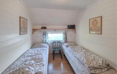 a small room with two beds and a chair at Lovely Home In Urangsvåg in Steinsbø