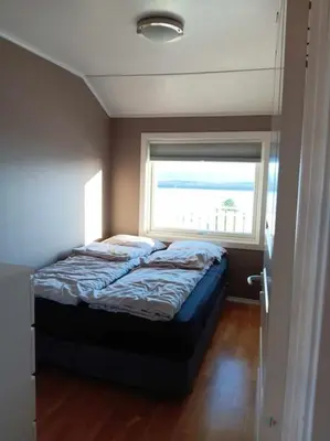 a small bedroom with a bed with a window at Sentralt, kort vei til byens fasiliteter in Molde
