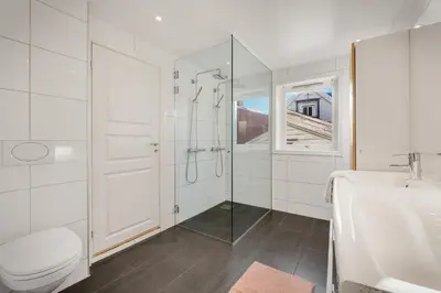 a white bathroom with a shower and a sink at The Townhouse Dream I Must See Views! in Bergen