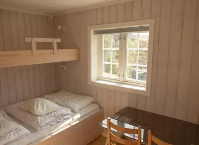 a small room with a bed and a window at Lägenhet med utsikt mot Gaustatoppen, ski in ski out in Gaustablikk