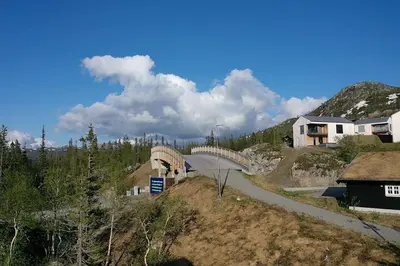 a bridge on top of a hill with houses at Lägenhet med utsikt mot Gaustatoppen, ski in ski out in Gaustablikk