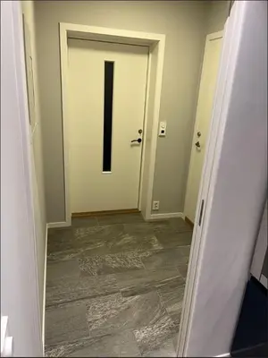an empty hallway with a white door with a black letter at Luxury apartment Bergen in Bergen