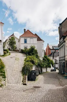 a cobblestone street in a town with white buildings at Dinbnb Apartments I Cobblestone Streets 350m from Bryggen & Fløybanen! in Bergen