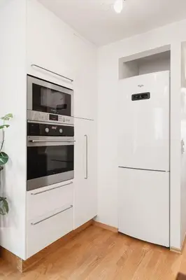 a white kitchen with a stove and a refrigerator at Dinbnb Apartments I Cobblestone Streets 350m from Bryggen & Fløybanen! in Bergen