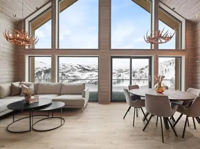 a living room with a couch and a table and chairs at Flygende utsiktshytte med magisk utsikt in Sogndal