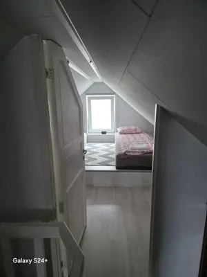 an attic room with a bed and a window at APARTAMENT Duże mieszkanie W centrum Ålesund in Ålesund