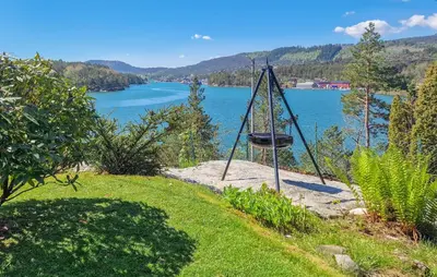 a swing on the side of a hill overlooking a lake at 4 Bedroom Awesome Home In Ølve in Ølve