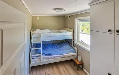 a small room with bunk beds and a window at 4 Bedroom Awesome Home In Ølve in Ølve