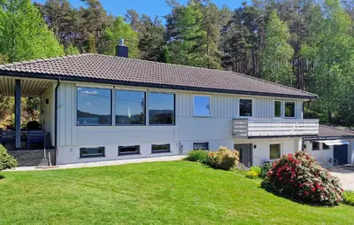 a white house with large windows and a yard at 4 Bedroom Awesome Home In Ølve in Ølve