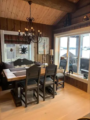 a dining room with a table and chairs and a chandelier at Ullsheim Grendehytte in Beitostøl