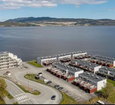 an aerial view of a parking lot next to a body of water at seaside house with stunning sunsets & sun all day Near Trondheim in Buvika