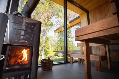 a living room with a fireplace in a house at Speilsuite med egen badstue og panorama in Steinkjer