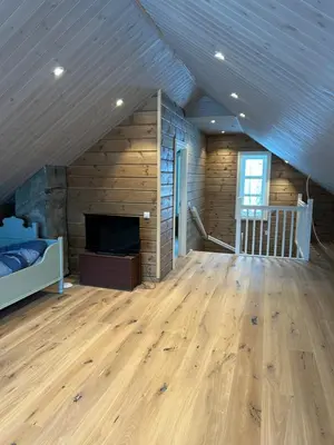 a room with a bed and a fireplace and wooden walls at Jostedal Lodge in Jostedal