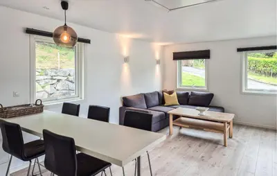 a living room with a table and a couch at Amazing Home In Haugesund in Haugesund