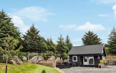 a small house on a hill with trees at Amazing Home In Haugesund in Haugesund