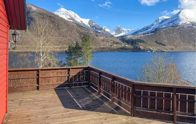 a deck with a view of a lake and mountains at Stunning Home In Lauvstad With House Sea View in Lauvstad