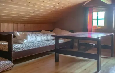 a room with a bed and a table in a cabin at Stunning Home In Lauvstad With House Sea View in Lauvstad