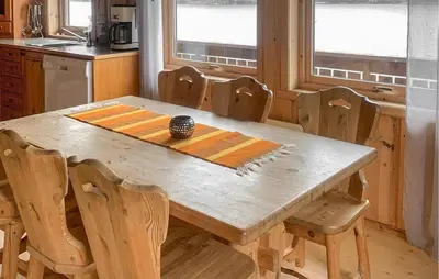 a wooden table and chairs in a kitchen at Stunning Home In Lauvstad With House Sea View in Lauvstad