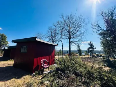a red shed with a pink chair in a field at Nydelig naturperle på Nesbyen, nær Langedrag in Nesbyen