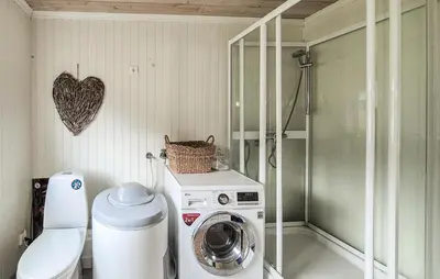 a bathroom with a washing machine and a heart on the wall at 2 Bedroom Lovely Home In Haugesund in Haugesund