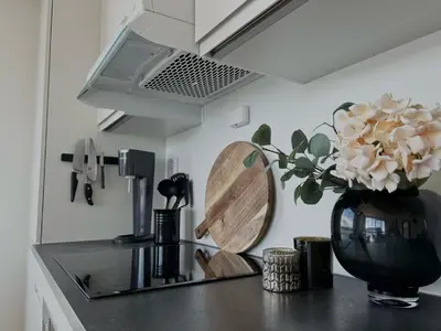 a kitchen counter with a vase with flowers in it at MJOS TOWER - Balcony Suite with lake view in Ringsaker