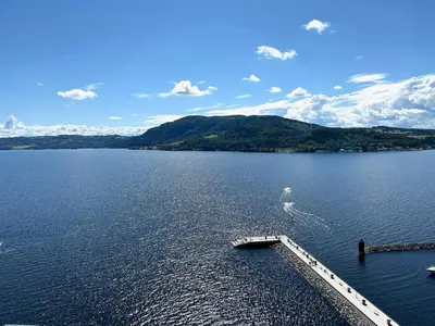 a large body of water with a pier in it at MJOS TOWER - Balcony Suite with lake view in Ringsaker