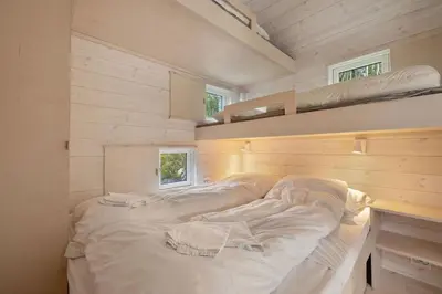 a bed in a small room with two bunk beds at Tiny Mountain Cabin I in Stranda