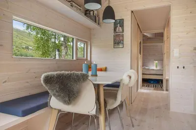 a tiny house with a table and chairs at Tiny Mountain Cabin II in Stranda