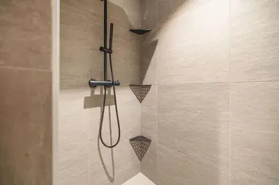 a shower with a shower head in a bathroom at Mountain View Apartment - 102 in Stranda