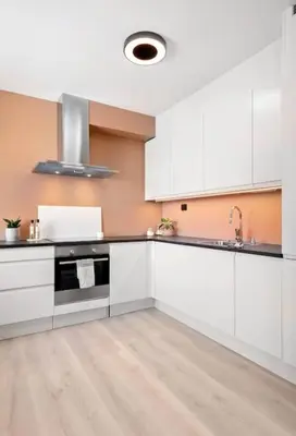 a kitchen with white cabinets and a sink at Sentral leilighet i Brosundet in Ålesund