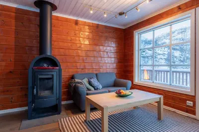 a living room with a couch and a stove at Handeland Lodge Near Trolltunga and Pulpit Rock Sleeps 18 with Sauna in Sauda