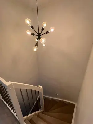 a chandelier hanging from a ceiling with a staircase at Sunny gateaway Room in Lerstad, Suitable for two guests in Ålesund