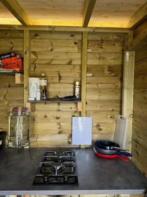 a kitchen with a stove top in a wooden cabin at Handeland Lodge I Arctic Dome in Sauda