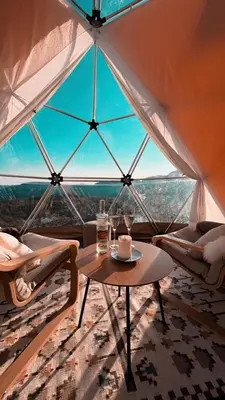 a table and chairs in a room with a large window at Handeland Lodge I Arctic Dome in Sauda