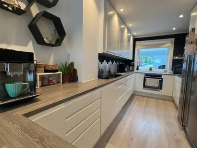 a large kitchen with white cabinets and a window at Cozy Urban Single Room in Ålesund